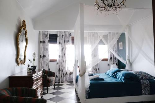 um quarto com uma cama azul e uma janela em Villa Beauregard em Sainte-Luce