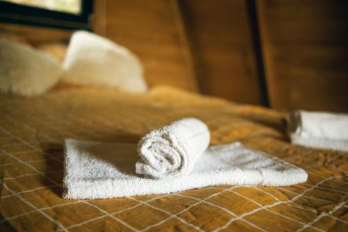 a pile of towels sitting on top of a bed at Unique Lake House Paradiso in Zvornik
