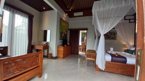 a bedroom with a bed with a canopy at Ubud Paradise Villa in Ubud