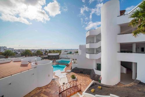 een uitzicht op een gebouw met een zwembad bij Apartamentos Lanzarote Paradise Colinas in Costa Teguise