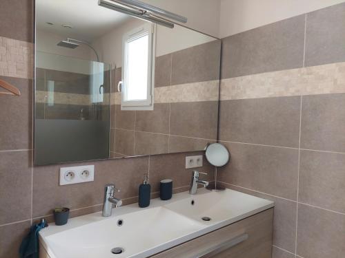 a bathroom with a sink and a mirror at Magnifique suite familiale in Nans-les-Pins