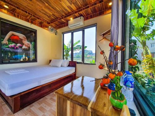a bedroom with a bed and a desk and a window at Ninh Binh Royal Homestay in Ninh Binh