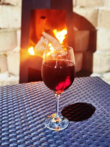 a glass of wine sitting on a table in front of a fireplace at Aurora's Rest 47 in Fisherhaven