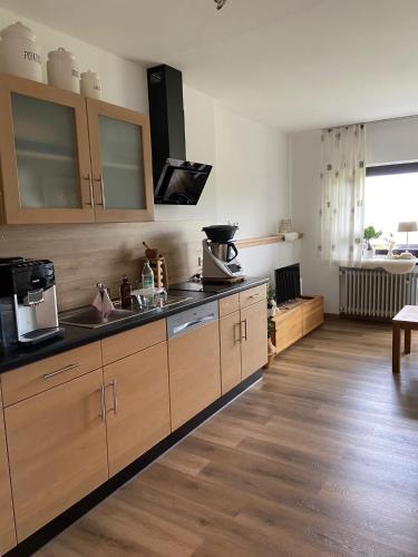 a kitchen with wooden cabinets and a counter top at Bergkristall 304 in Hauzenberg