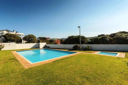 a swimming pool in a yard next to a fence at Aurora's Rest 47 in Fisherhaven