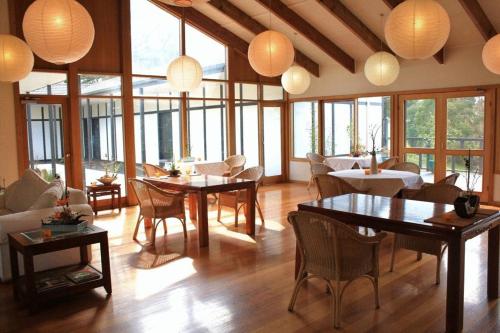 a living room with tables and chairs and lamps at Shizuka Ryokan Japanese Country Spa & Wellness Retreat in Hepburn Springs