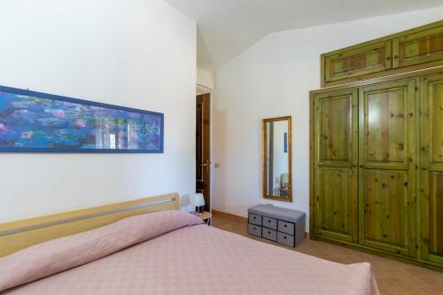 um quarto com uma cama e um armário de madeira em Statzu Butzu em Costa Paradiso