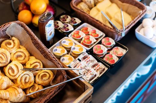 a table with baskets of pastries and other foods at B&B HOTEL Geneva Airport in Geneva