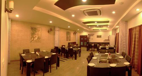 ein Restaurant mit Tischen und Stühlen in einem Zimmer in der Unterkunft Hotel Royal Palm - A Budget Hotel in Udaipur in Udaipur