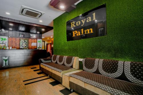 un ristorante con una fila di panchine contro un muro verde di Hotel Royal Palm - A Budget Hotel in Udaipur a Udaipur