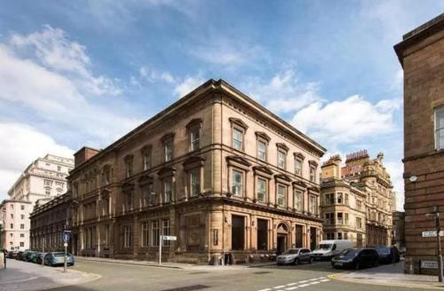 a large brick building with cars parked in front of it at Duplex 2-bedroom apartment in Liverpool centre in Liverpool