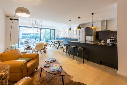un salon et une cuisine avec un canapé et une table dans l'établissement Maison d’hôtes, terrasse & jacuzzi en plein centre, à Bordeaux
