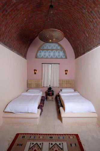 a bedroom with two beds and a large ceiling at Tzila Bahariya in Az Zaytūn