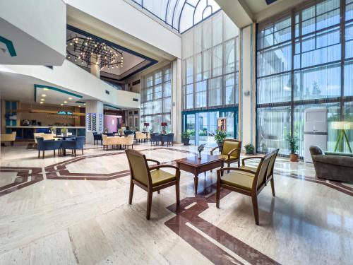 a lobby with chairs and tables in a building at Spa Hotel Colossae Thermal in Pamukkale