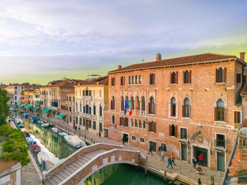 a bridge over a canal in a city with buildings at Palazzo Marcello Hotel Al Sole in Venice