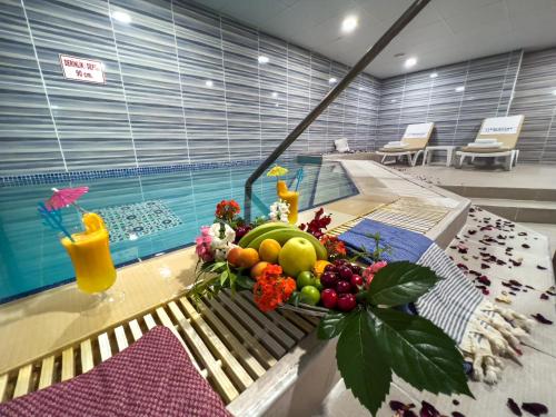 a bowl of fruit on a table next to a swimming pool at Spa Hotel Colossae Thermal in Pamukkale