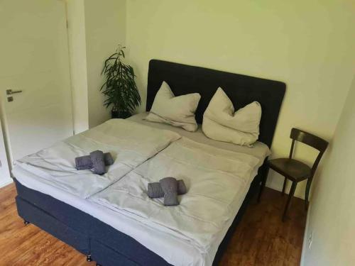 um quarto com uma cama com duas almofadas e uma cadeira em Ein Zuhause mit schönem Garten em Bona