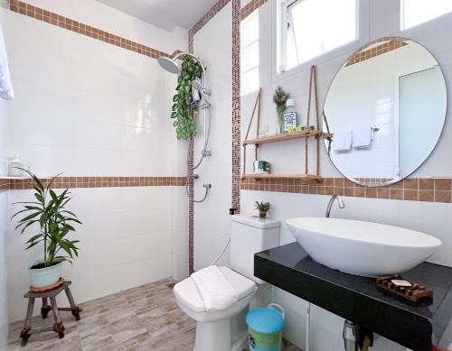 een badkamer met een witte wastafel en een spiegel bij Sea Dreamer Beachfront Apartments in Phuket