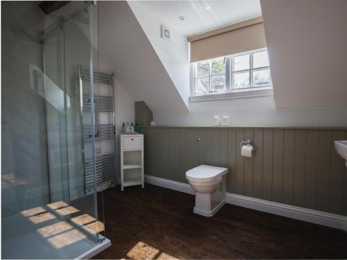 a bathroom with a toilet and a glass shower at Queens in Winchcombe
