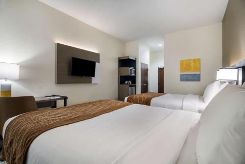 a hotel room with two beds and a tv at Comfort Inn & Suites Victoria North in Victoria