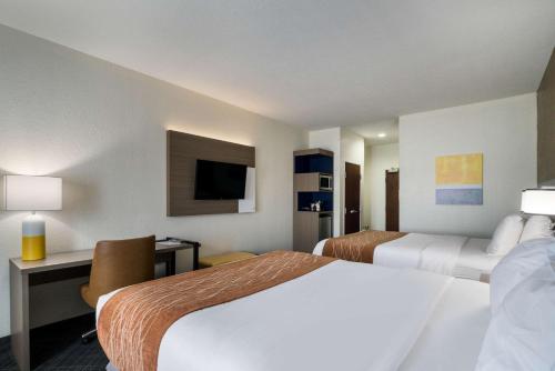 a hotel room with two beds and a desk at Comfort Inn & Suites Victoria North in Victoria