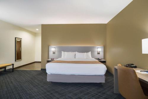 a hotel room with a large bed and a desk at Comfort Inn & Suites Victoria North in Victoria