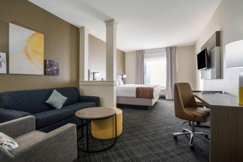 a hotel room with a couch and a bed at Comfort Inn & Suites Victoria North in Victoria