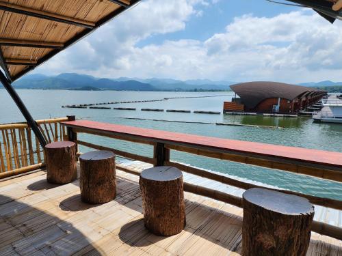 a wooden deck with a bench on the water at บ้านไร่ วรรณ วาลย์ รีสอร์ท in Tha Kradan