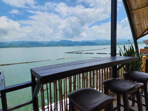 a balcony with chairs and a view of the water at บ้านไร่ วรรณ วาลย์ รีสอร์ท in Tha Kradan