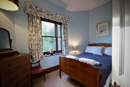 a bedroom with a bed and a window and a dresser at Glen Hill in Deal