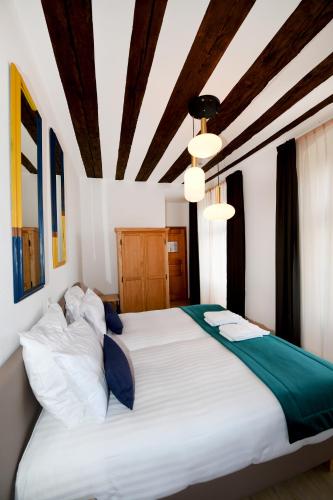 a bedroom with a large bed with white sheets at Hôtel de Ville d'Ollon in Ollon
