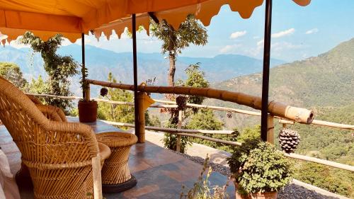 a balcony with chairs and a view of the mountains at Ananta Prana in Mussoorie