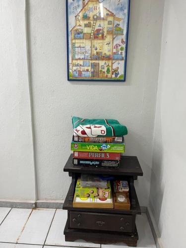 a stack of books on a table next to a wall at Aquarela Suítes in Piúma