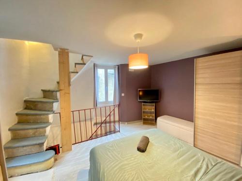 a bedroom with a staircase and a bed in a room at Agréable maison de ville avec parking gratuit in Corent