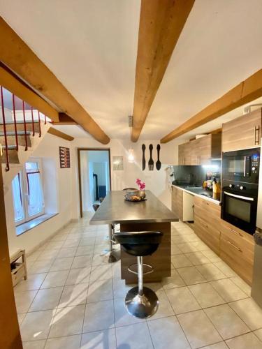une grande cuisine avec un îlot au milieu dans l'établissement Agréable maison de ville dans petit village auvergnat, à Corent