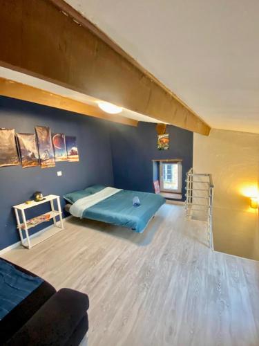 une chambre avec un lit dans une pièce bleue dans l'établissement Agréable maison de ville dans petit village auvergnat, à Corent