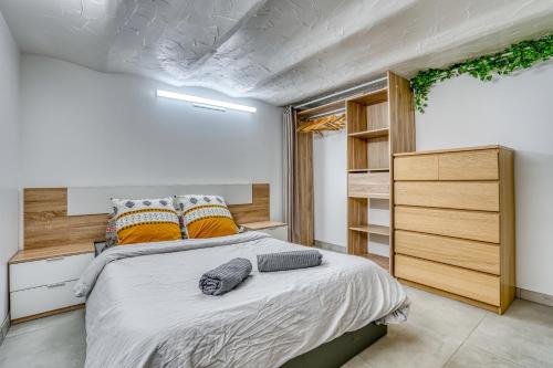 - une chambre avec un grand lit et des oreillers orange dans l'établissement Sous-sol aménagé 32m2 - Proche Paris, à Aubervilliers
