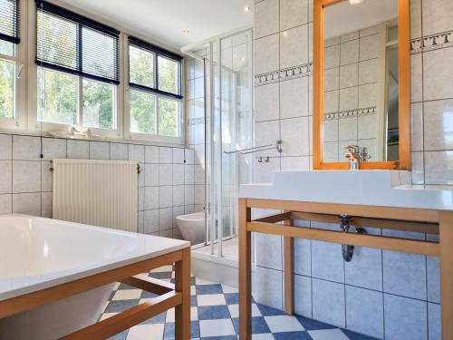 a bathroom with a sink and a tub and a toilet at Prachtig vakantiehuis in Domburg DO38 in Domburg