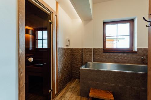 a bathroom with a large tub and a window at Wellness penzión Kráľov dvor in Čremošné