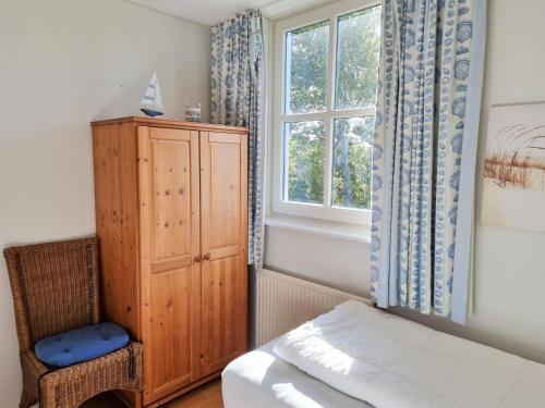 a bedroom with a bed and a window and a chair at Prachtig vakantiehuis in Domburg DO38 in Domburg