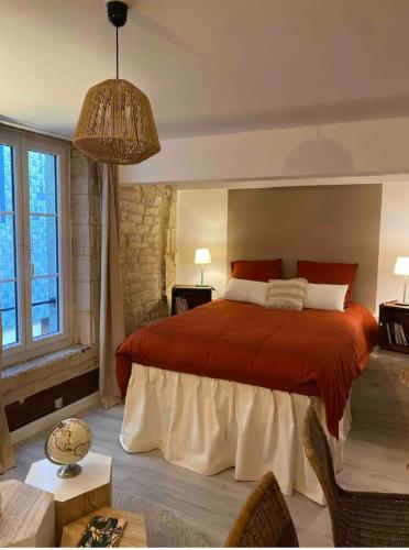 a bedroom with a large bed with a red blanket at Studio hyper centre de Caen in Caen