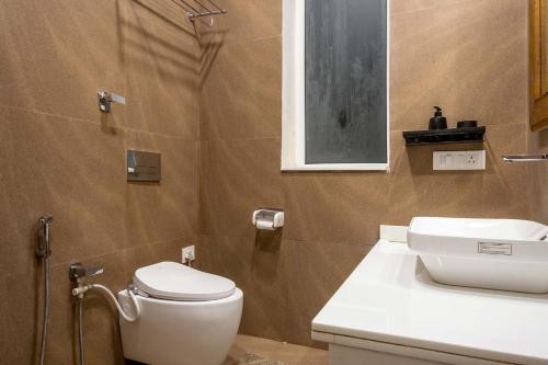 un baño con inodoro y lavabo en StayVista at Slice of Heaven, en Mussoorie