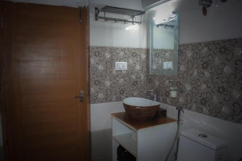 La salle de bains est pourvue d'un lavabo et d'une porte en bois. dans l'établissement Ibni Springs, à Madikeri