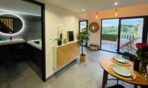 a bathroom with a sink and a table with a dining room at Spa & vue Mer - Les Ô de Bandol in Bandol