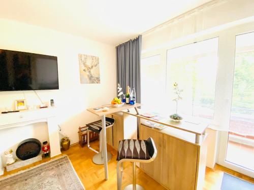 ein Heimbüro mit einem Schreibtisch und einem großen Fenster in der Unterkunft Welcome to Messe! Two-bedroom SmartApartment &Balcony in Hannover