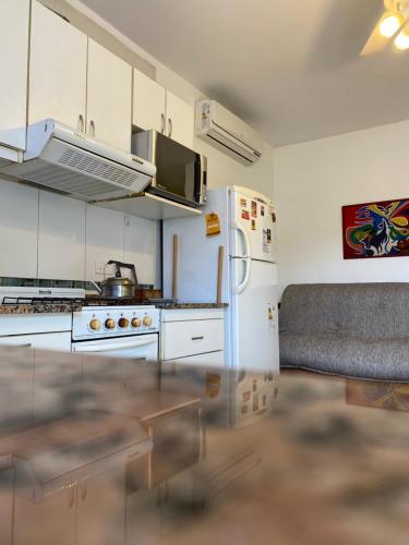 Una cocina con gabinetes blancos y un refrigerador blanco. en Deptos Drei Kinder, en Belén de Escobar