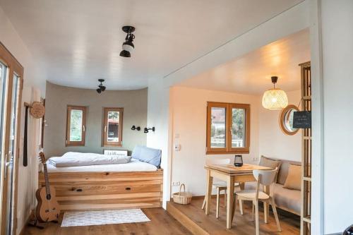 Un dormitorio con una cama y una mesa con una guitarra en Wohnwagon Paul - Autarkie erleben! - Tiny House en Oberschneiding