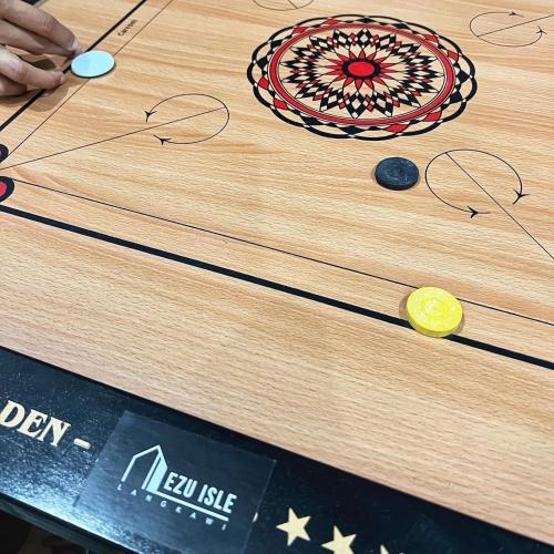 a wooden table with a game on top of it at Ezu Isle Langkawi Pool Villa in Pantai Cenang