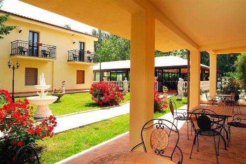 an outdoor patio with tables and chairs and flowers at Le Naiadi Park Hotel Sul Lago in Bolsena