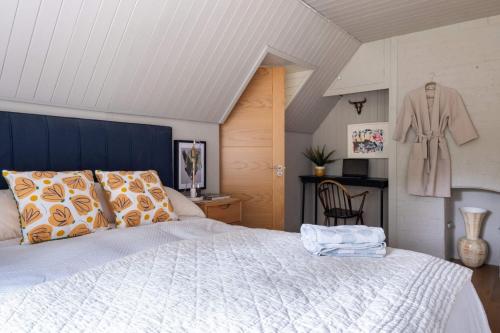 1 dormitorio con cama y albornoz colgado en la pared en Ridge Cottage, en Bransgore